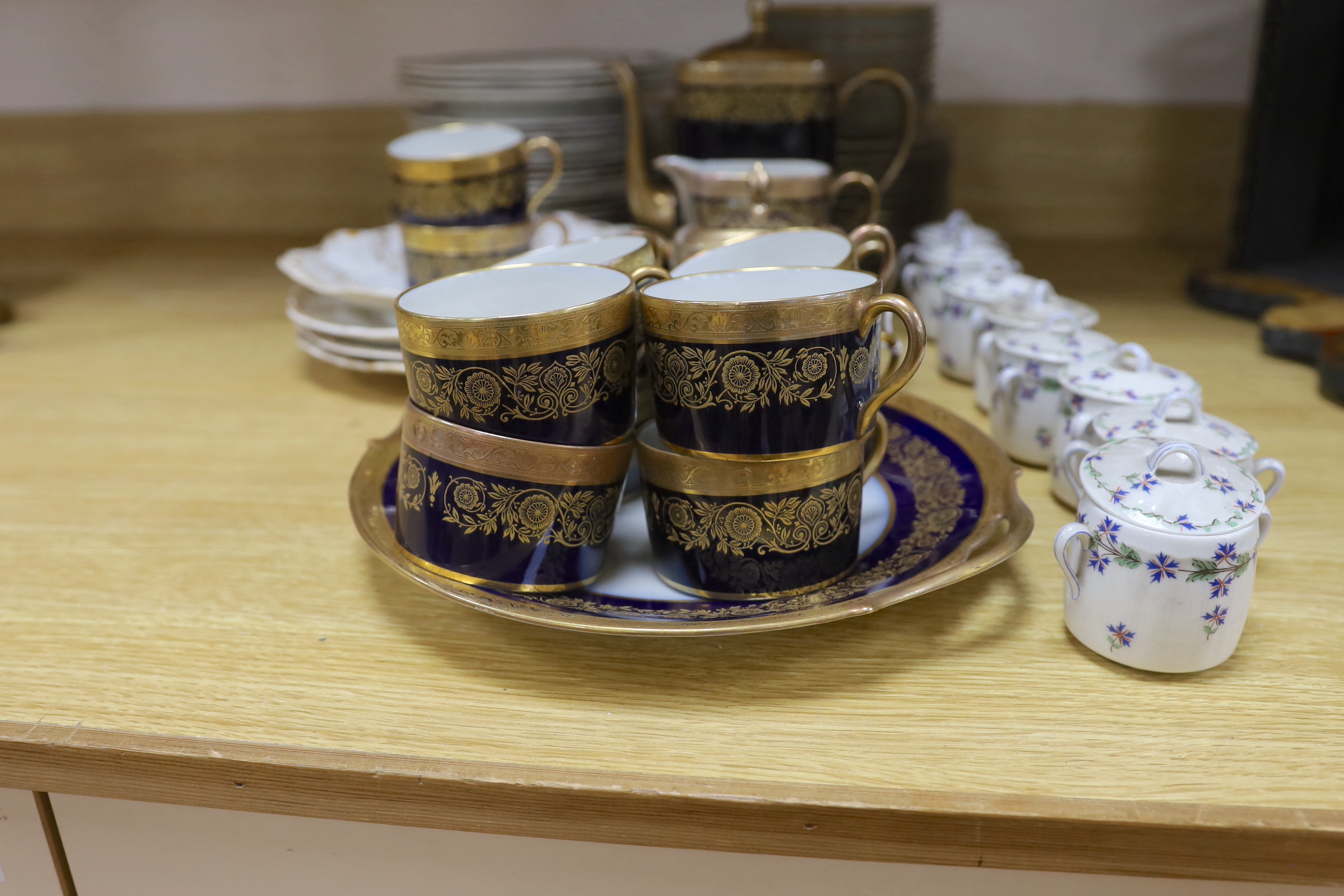 A Raynaud and Co. Limoges gilt and navy ten cup coffee service, a Woodsware part dinner service and eight Limoges floral pots and covers
